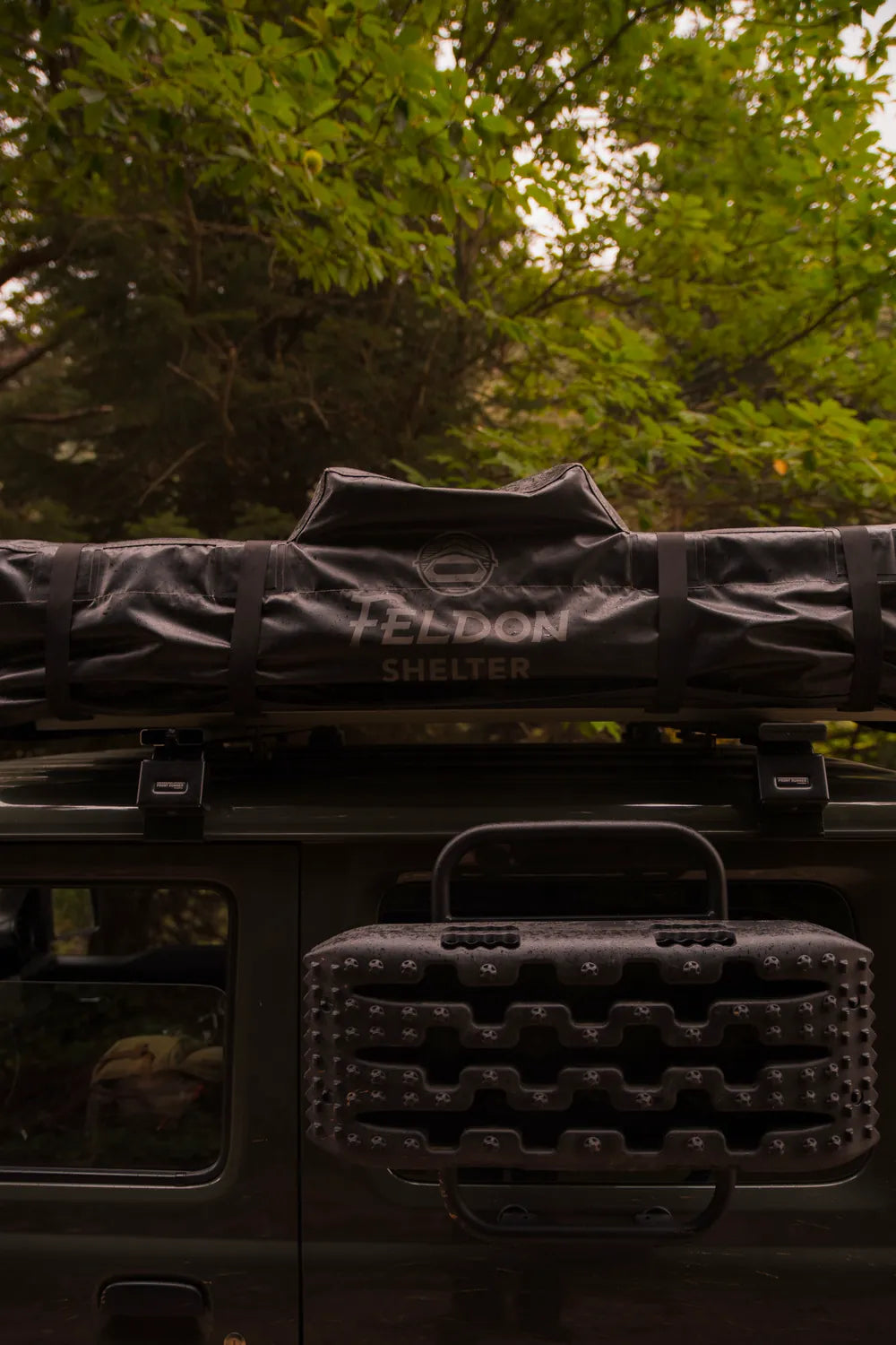 Feldon Shelter Crow's Nest roof top tent and recovery boards mounted on the green Jimny