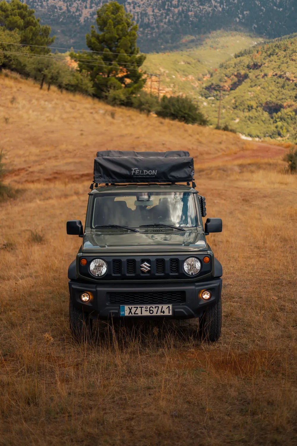 Front view of the green Suzuki Jimny Crow's Nest in a golden mountain meadow