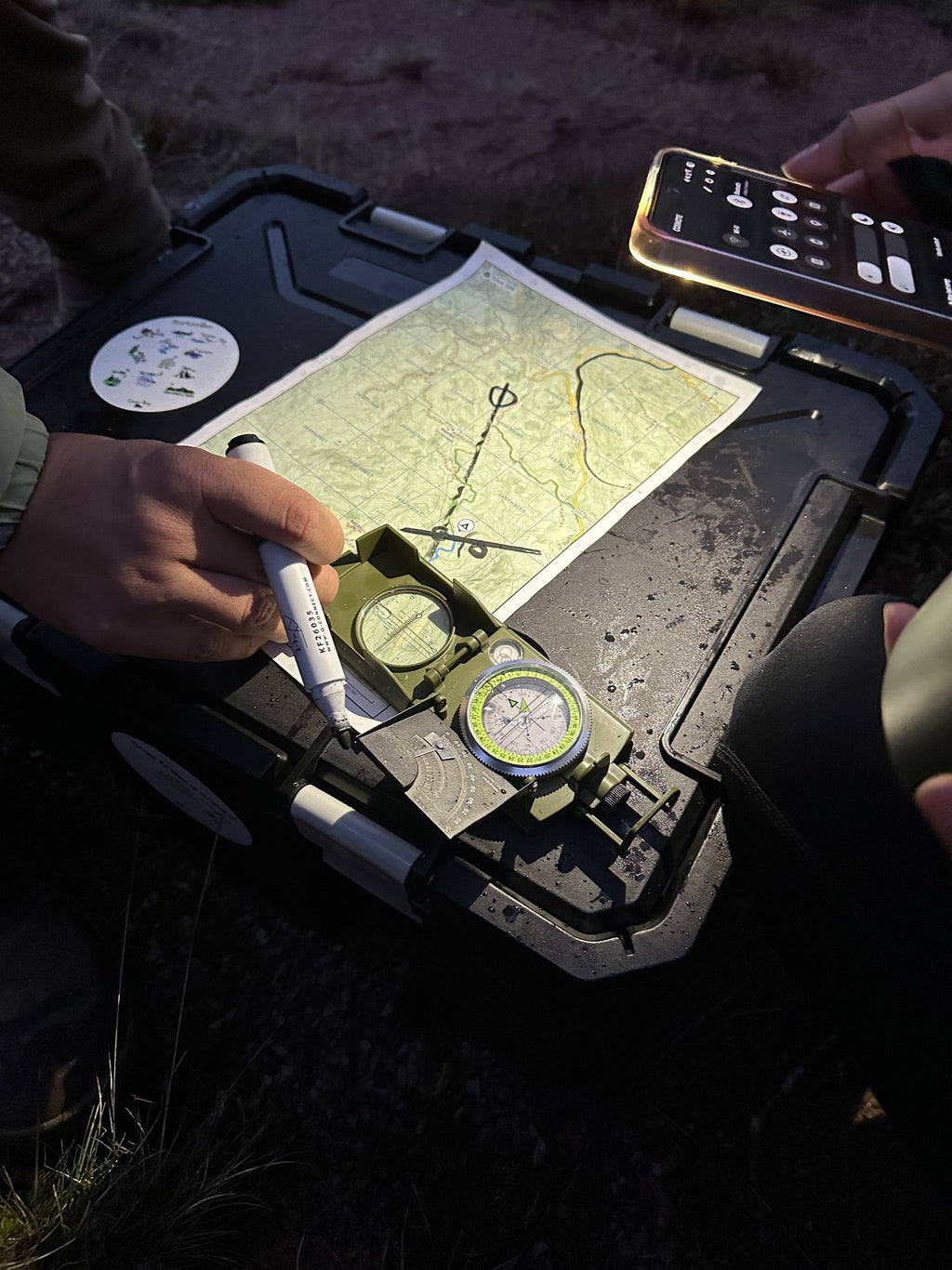 A map and compass on a vehicle bonnet during the navigation and off-road session