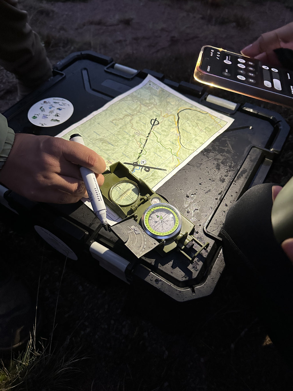A map and compass on a vehicle bonnet during the navigation and off-road session